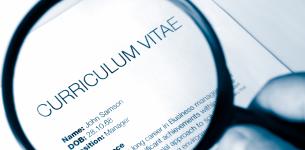 Image of a printed CV being looked at through a magnifying glass