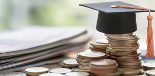 An image of a university mortar cap sitting on a pile of coins.