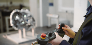 For employers: A photograph of an apprentice using a remote control device in a manufacturing setting/