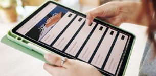 An image of someone holding a tablet device which is displaying job listings.