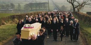A funeral procession for a victim of a road traffic accident.