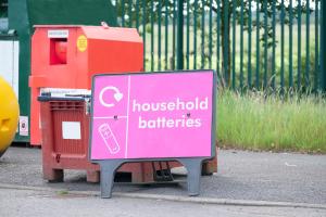 Image of a 'household batteries' sign at a recycling centre