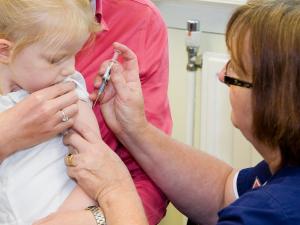 pre-school child getting an injection in her upper arm