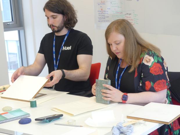 two PRONI staff members participating in a book-binding workshop