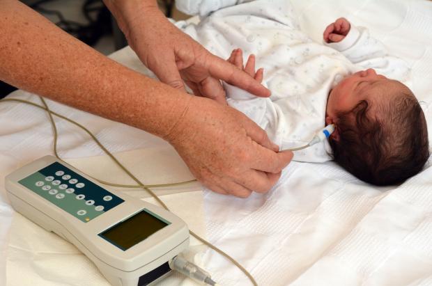 A baby having its hearing tested as part of newborn screening